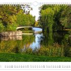 Text: „Schlossbereich, Juli“. Eine grüne Landschaft mit See und Brücke, umgeben von Bäumen. Kalenderansicht.