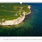 Kalenderblatt Juli, zeigt Kap Arkona mit steilen Kreideklippen, grünen Feldern und blauem Meer aus der Luftperspektive.