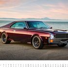 JULI, 1-31 unten im Kalender. Ein klassisches, weinrotes Sportauto vor Meer und Sonnenuntergang.
