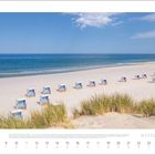 Juli 2027, Meer, Sandstrand mit Strandkörben, blauer Himmel mit wenigen Wolken, Gras im Vordergrund.
