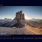 "04 April" und Kalender darunter. Felsformation im Sonnenuntergang, umgeben von Bergen.