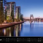 Text: "Berlin 07", "Treptowers und Berliner Molecule Man". Eine abendliche Uferansicht mit modernen Gebäuden und Skulptur.