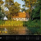 Dänemark 07. Kalender mit reetgedecktem Haus, umgeben von Bäumen und einem Teich mit Seerosen.