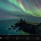 Kalenderseite: "Nordlichter", Monat Juli. Farbiges Nordlicht am Nachthimmel über einer felsigen Küste.