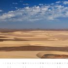 Kalenderblatt mit Datum 07 und der Darstellung von Sanddünen unter blauem Himmel mit Wolken.