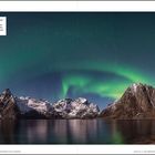 Leuchtende grüne Nordlichter über schneebedeckten Bergen spiegeln sich im ruhigen Wasser unter einem klaren Nachthimmel.