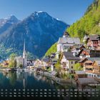 Text: "Hallstatt Österreich". Kalenderübersicht unten. Malerische Stadt mit Kirche am See, umgeben von Bergen.