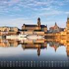 Kalender: Zahlen von 1 bis 31, Wochentage darunter. Stadtansicht mit historischen Gebäuden am Flussufer.
