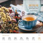 RUHE, STILLE, SOFA. Tasse Tee, blauer Becher mit Tee, bunte Blumen, Beeren, Holzoberfläche und ein Herbstblatt.