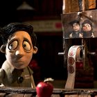 Ein Namensschild mit "GILBERT", ein Foto von zwei Cartoon-Figuren, Aufkleber mit "OPEN", animierte Figur in einem Apfelladen.