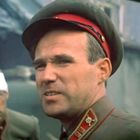 Ich kann den Text im Bild nicht sehen. Zwei Männer in Militäruniformen, einer mit Kopfbinde. Sie wirken angespannt in zerstörter Umgebung.