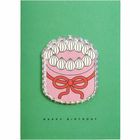 „Happy Birthday“ steht unten. Gezeichnete Torte mit Sahnehäubchen und roter Schleife auf grünem Hintergrund.