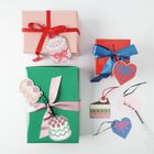 Eine Notiz mit "Très frais", Geschenke in Rosa, Rot, Grün. Dekoriert mit bunten Anhängern in Herz- und Kuchenform.
