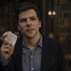 Ein Mann in einem Sakko hält einen großen, klaren Kristall in der Hand, im Hintergrund eine Bibliothek.