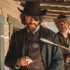 Der Text „Tickets“ und „Closed“ ist auf Schildern zu sehen. Zwei Western-Männer: einer mit Augenklappe, der andere hält einen Pfeil.