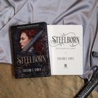 Titel: "STEELBORN". Darunter: "The Steelborn Saga, Book 1" und "Taylor J. LaRue". Links ein Buchcover mit Frau und Schwert.
