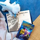 Links ein Buch mit Kapitel "2", daneben ein Kinderbuch-Cover: "THE LAST IMMORTALS". Ein Plüschtier liegt daneben.