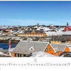 "Nuuk, Hauptstadt" steht unten links. Im Vordergrund bunte Häuser, im Hintergrund verschneite Hügel mit klarem blauem Himmel.