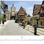 Kalenderblatt mit August-Kalender. Pflasterstraße in Rothenburg ob der Tauber, umgeben von Fachwerkhäusern und einem Turm.