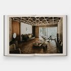 Ich sehe keine Texte im Bild. Es zeigt einen stilvollen Raum mit Holzboden, Sofa, Sessel und einem großen Fenster.