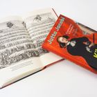 Ein Buchcover zeigt "Jutta Jacobi: Königin ohne Land", daneben ein Buch mit einer historischen Illustration.