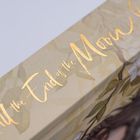 "Till the End of the Moon" steht in goldener Schrift auf einer beige-farbenen Box mit Blumenmotiven.