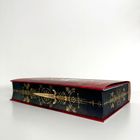Ein rotes Buch mit einem kunstvollen goldenen Schwert-Design auf dem Buchrücken.