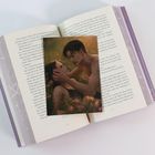 Geöffneter Roman mit lila Einband. Darauf eine romantische Illustration eines Paares in sommerlicher Natur.