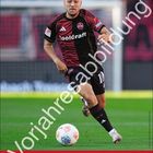 "VJ Julian Justvan Der Club August", ein Fußballspieler in rot-schwarzem Trikot mit Kalender unten.