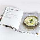 Text: "Klassischer Hummus" Rezeptseite mit einer Schüssel Hummus, dekoriert mit Petersilie und Olivenöl.
