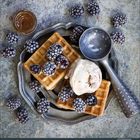 Kalenderdaten unten; Waffeln mit Eiscreme, Brombeeren und einem Eislöffel auf einem Teller.