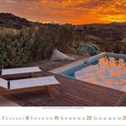 8. Aug. 2023 zeigt einen Sonnenuntergang über einem Pool mit zwei weißen Liegen und einer Hügellandschaft.