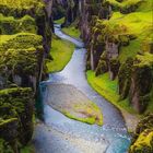 Kalenderseite August 2027; grüne Schlucht mit mäandrierendem Fluss, umgeben von moosbedeckten Felsen.
