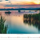 Kalender, Oktober 2024: Fotografie einer mittelalterlichen Wasserburg umgeben von Wasser, im Hintergrund Berge.