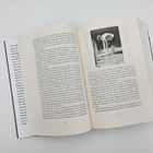 Seite 134 und 135 eines Buches mit Text. Auf Seite 135 ein Schwarzweißfoto einer Person, die draußen etwas schaufelt.