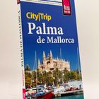 "City|Trip Palma de Mallorca" oben. Ein Reiseführer mit einem Bild der Kathedrale La Seu, Palmen und Booten im Vordergrund.