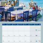 "Es kommt nicht darauf an, dem Leben mehr Jahre zu geben, sondern den Jahren mehr Leben zu geben." Alexis Carrel. Malerische Hafenansicht mit blau-weißen Tischen und Booten. Kalender für August 2027.