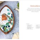 Holztablett: Ein Holztablett mit Vogelmotiv, umgeben von Beeren und Blättern. Liste der benötigten Materialien rechts.