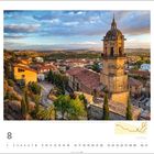 Kalendermonat 8 mit faszinierendem Blick auf eine Stadtlandschaft und eine markante Glockenturmkirche bei Sonnenuntergang.