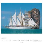 Star Clipper, Malta Heimathafen. August 2027 Kalenderblatt. Großes Segelschiff vor Felsformation und blauem Himmel.