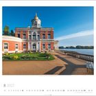 8 2027. Marmorpalais, Neuer Garten, Potsdam. Ein rotes Backsteingebäude mit Kuppel, dahinter ein See und blauer Himmel.