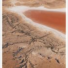 August, Lake Eyre, South Australia, Australia. Luftaufnahme einer trockenen Wüstenlandschaft mit rötlichem Gewässer.