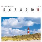 21.6.-22.7. Leuchtturm auf einer Düne unter blauem Himmel mit Wolken.