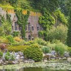 „Grüne Festung. Die alte Festung Fort Hoofddijk aus dem 19. Jahrhundert wurde mitsamt ihrer Gebäude und Wälle ab den 1960er-Jahren fachgerecht in den Botanischen Garten von Utrecht integriert, der zur Universität gehört und als einer der ältesten botanischen Gärten der Welt gilt.“ Kalender mit Juni und Juli, grüne Natur mit Pflanzen vor einer Festung.