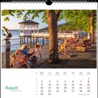 Kalenderseite August, entspannte Menschen in Liegestühlen am Wasser, Steg mit Pavillon, sonniger Nachmittag, beruhigende Szenerie.