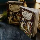 "JESSICA ROUX WOODLAND WARDENS TAROT" auf Buchdeckel und Schachtel, verziert mit Illustrationen von Tieren und Pflanzen.