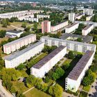 Leider kann ich keine erkennbaren Texte oder Namen in diesem Bild finden. Es zeigt eine Wohnsiedlung mit vielen grünen Flächen.
