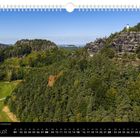 "Göhrisch und Papststein liegen nah beieinander." August-Kalenderblatt mit Wald, Felsen und Turm unter blauem Himmel.