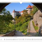 August. Blick auf den Burgwasserturm links und die Mühlbastei rechts. Historische Stadtbefestigung, umgeben von Bäumen und Mauern.