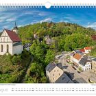 August, Blick über die Marienkirche hin zum Alten Forstgarten. Malerische Landschaft mit Kirche, Wald und Häusern im Tal.